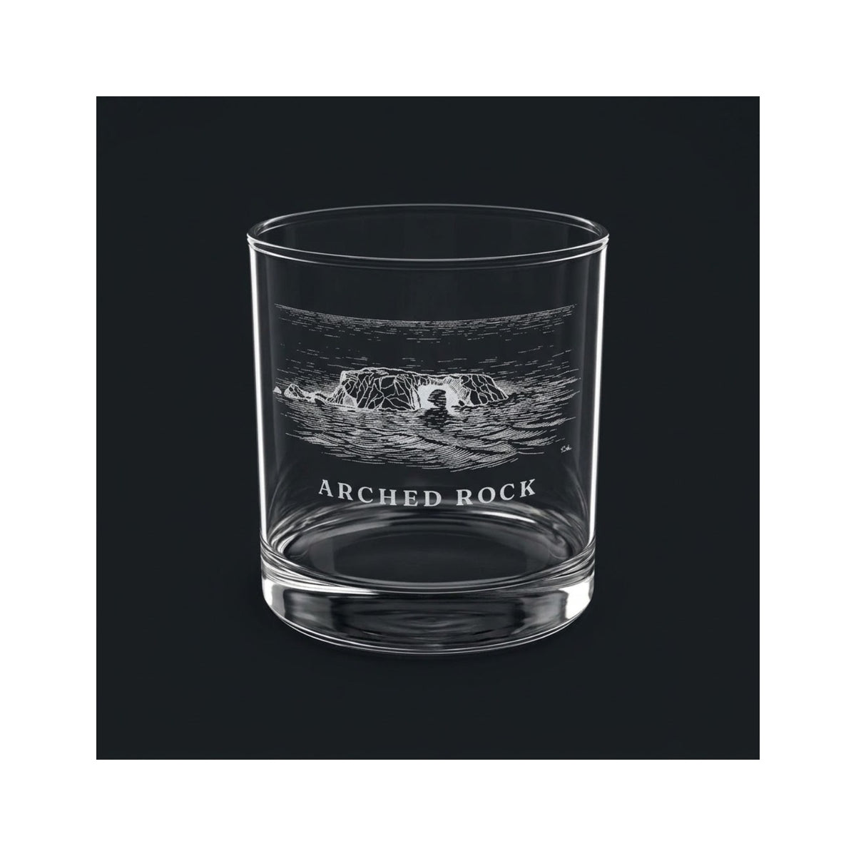 Engraved rocks glass with Arched Rock and the words ARCHED ROCK, shown on a dark background so the engraving stands out
