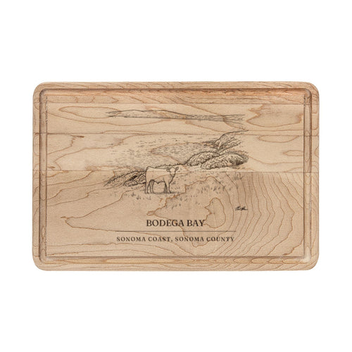 Maple cutting board engraved with a line drawing of a calf on a pasture above Bodega Bay